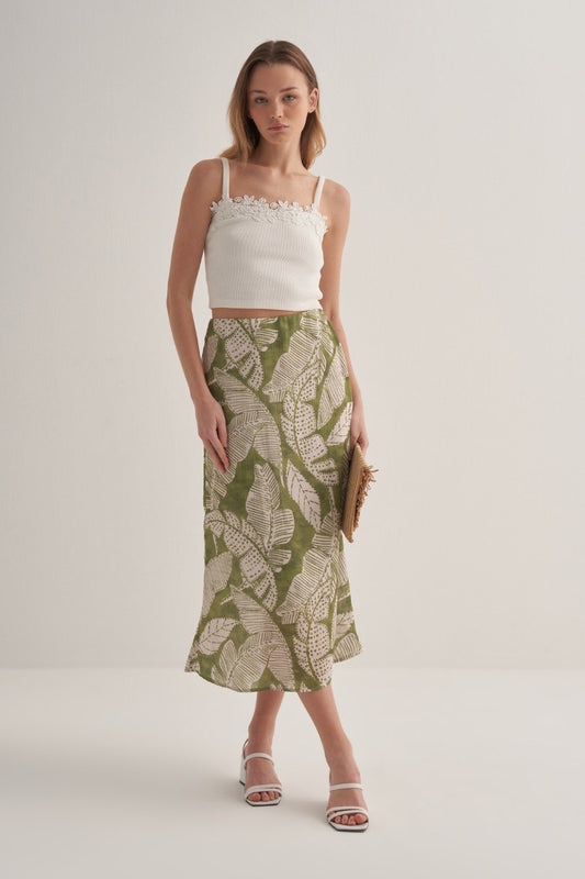 Front view of a tropical leaf print green skirt with mid-calf length.