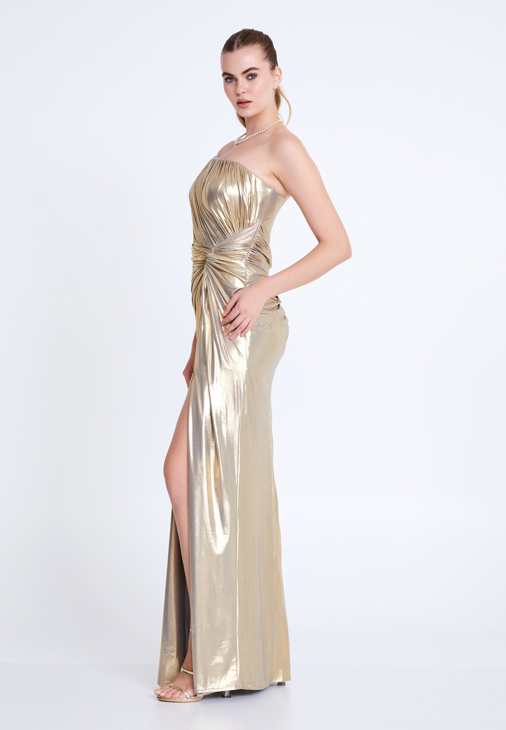Side view of gold strapless formal gown with shimmering finish