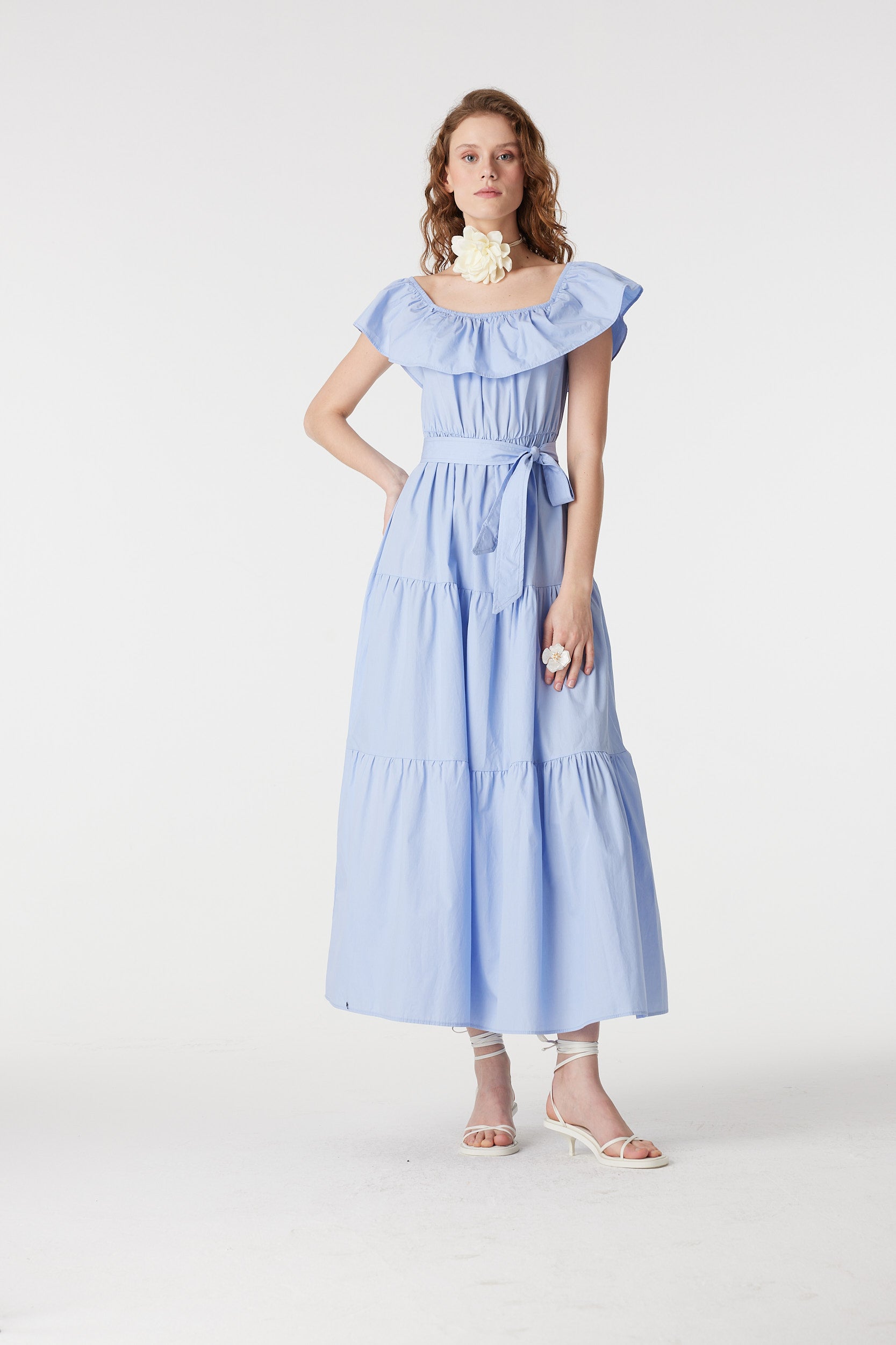 Model wearing baby blue off-shoulder tiered maxi dress with ruffle neckline and waist belt