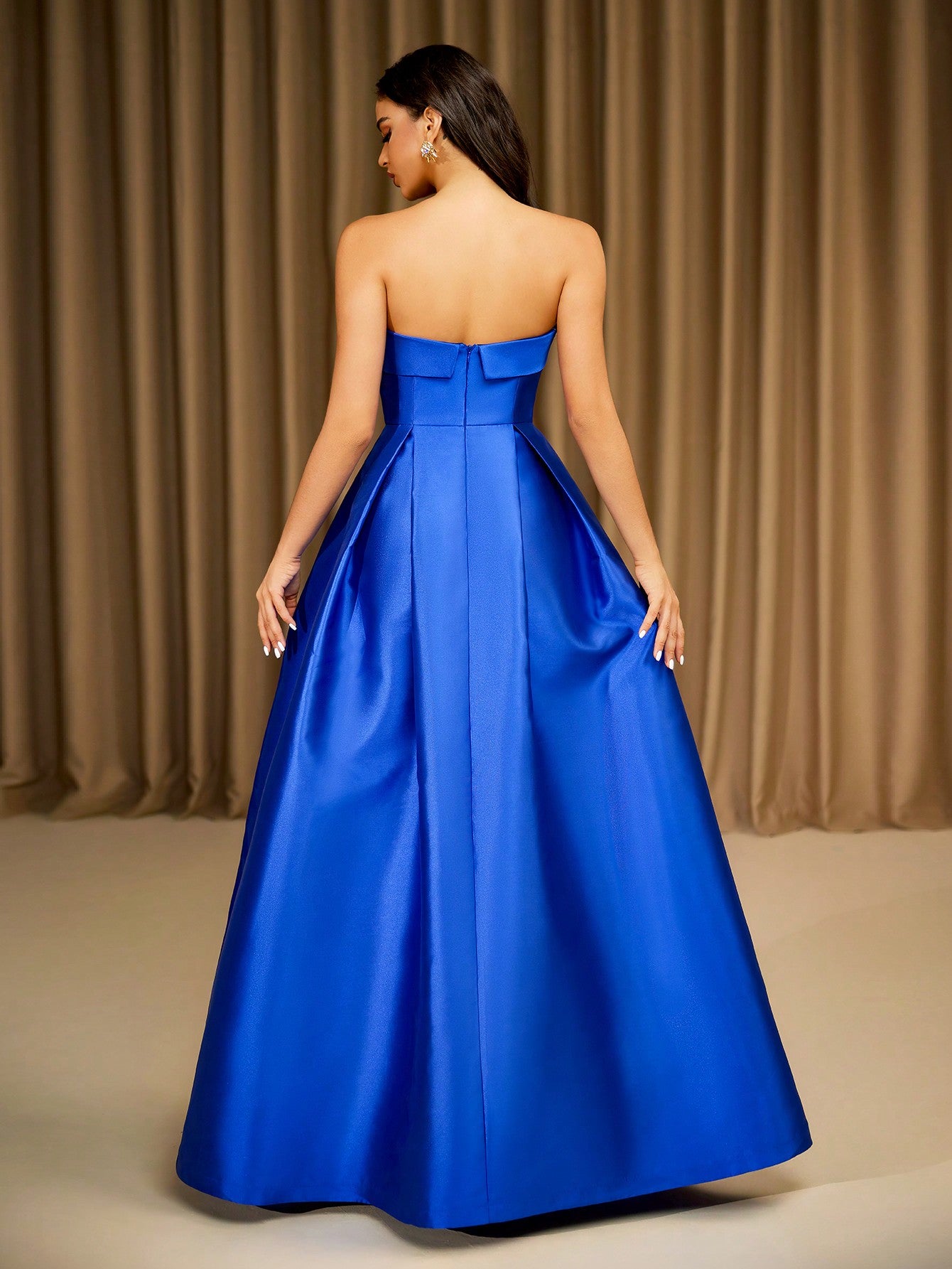 Back of strapless blue satin ball gown with structured seams and pleated skirt – classic formal dress
