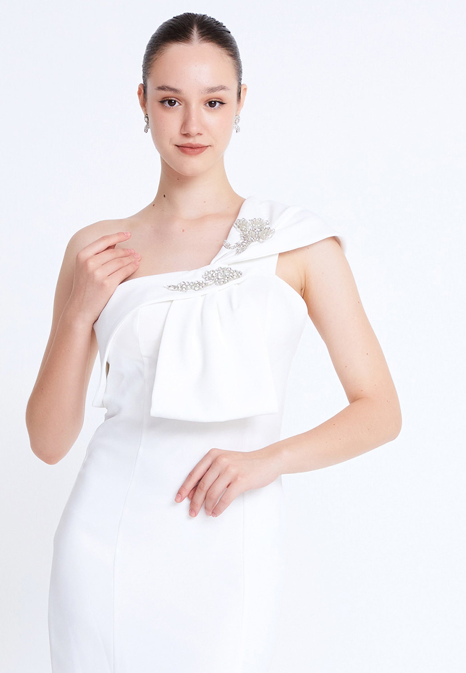 Close-up of embellished bow shoulder detail on white formal dress