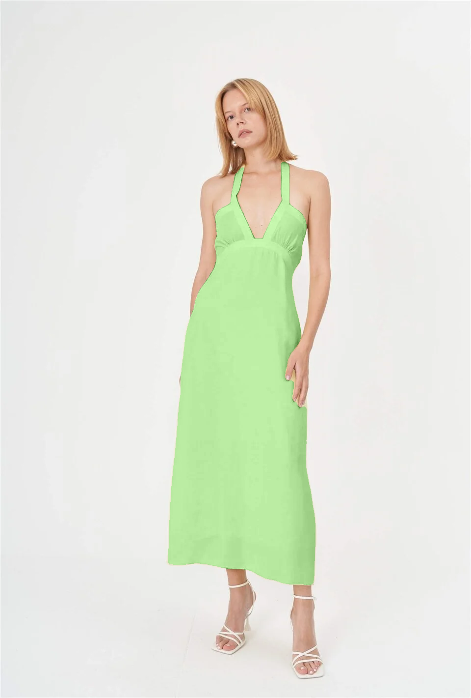 A vibrant green summer dress with a halter neck, made from lightweight cotton fabric. The dress is perfect for various occasions, including beach outings, pool parties, casual gatherings, and street style during hot summer days