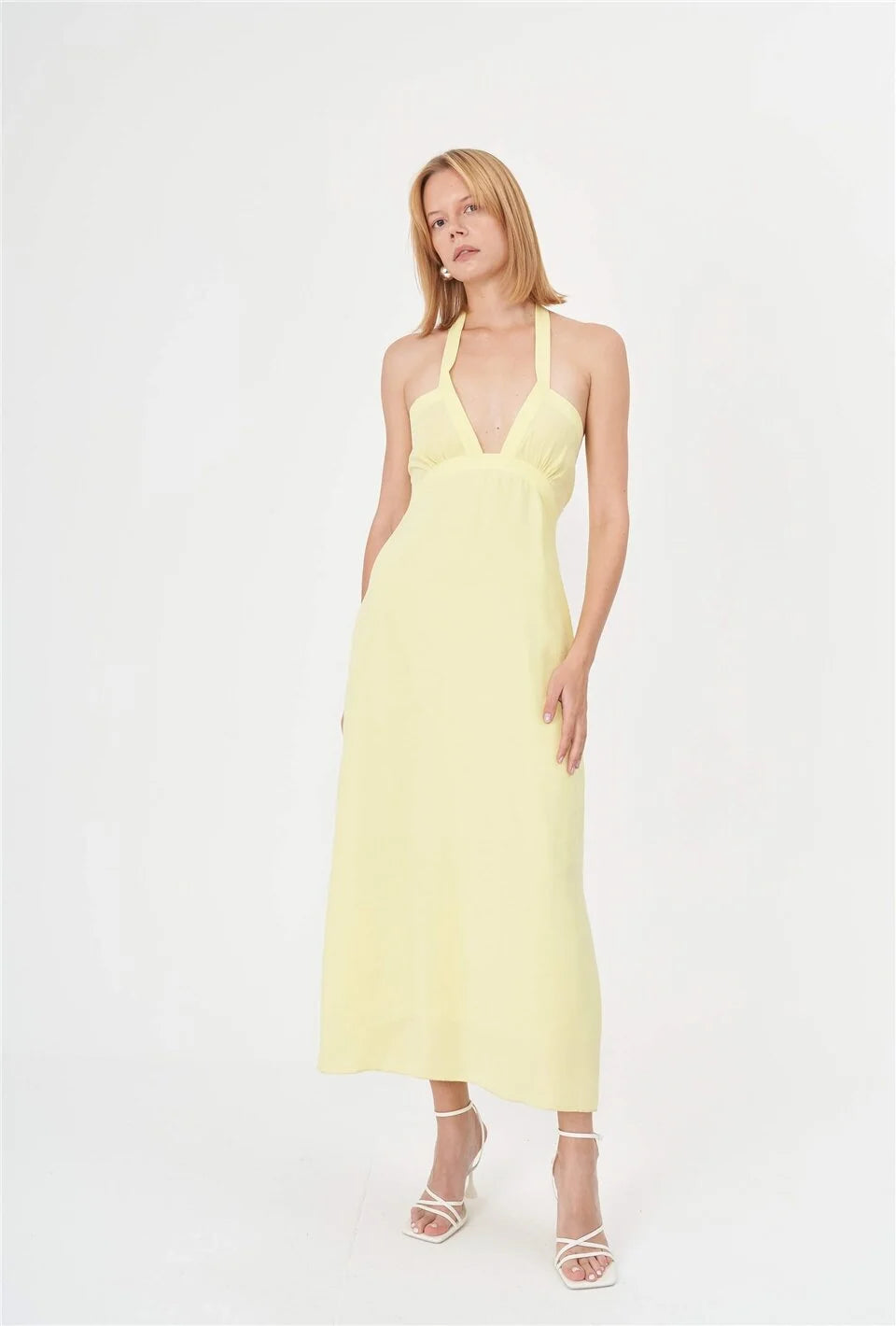 A sunny yellow summer dress with a halter neck, made from lightweight bio-based and organic fabric. This vibrant yellow dress is perfect for beach days, pool parties, social gatherings, and hot summer street style.
